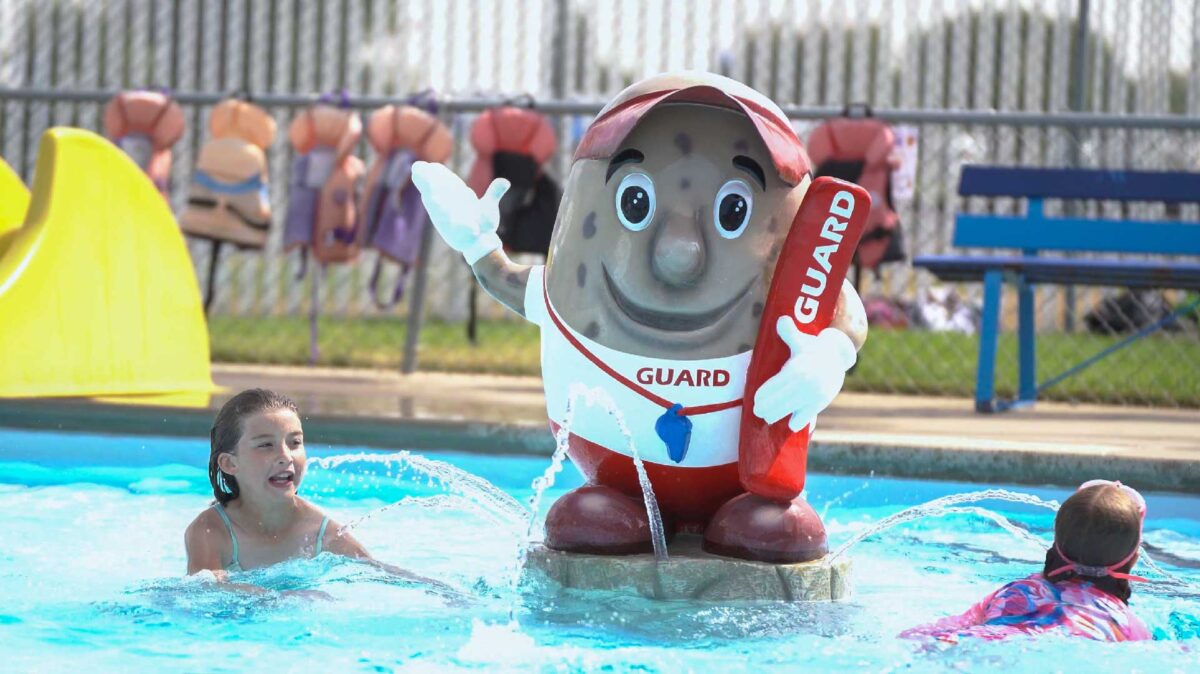 Bow Island pool swimmers around the mascot MacBean